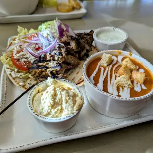 Pork souvlaki sandwich with side cup of tomato bisque soup (also comes with hummus and tzatziki).