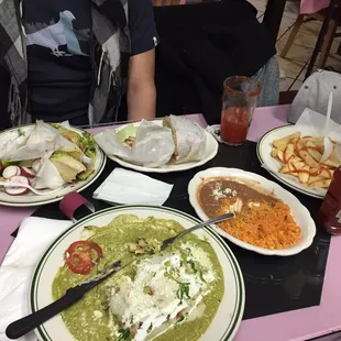 Enchiladas suizas de pollo, french fries, and tacos de carne enchilada.