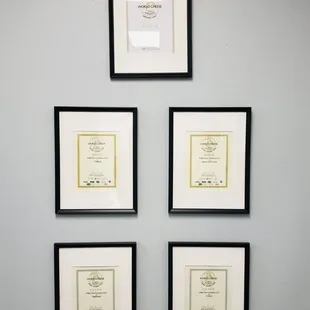 four framed certificates on a wall