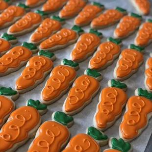 a tray of decorated pumpkin cookies