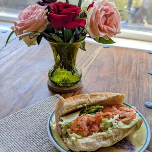a sandwich with tomatoes and lettuce