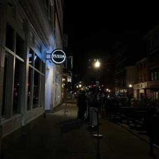 people walking down the sidewalk at night