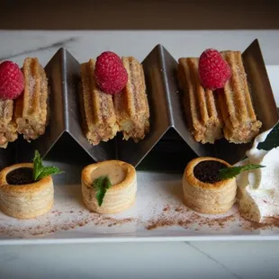 Churros with chocolate, raspberry and caramel sauce