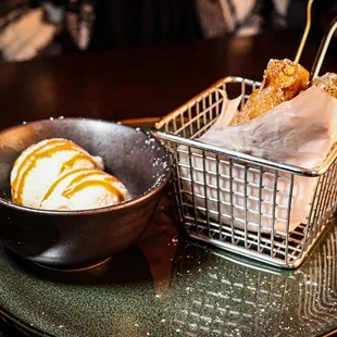 a bowl of ice cream and a basket of donuts