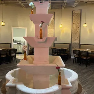a pink fountain with bottles on top