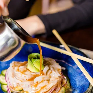 a plate of food being drizzled with sauce