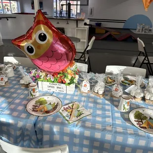 a table with plates of food and balloons