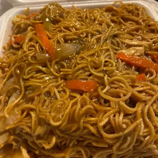 a take out container with noodles and vegetables