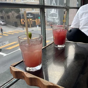two drinks on a table with a view of a street