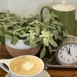 a cup of cappuccino and a clock