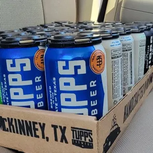 six cans of beer in a cardboard box