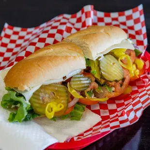 a sandwich with pickles and tomatoes