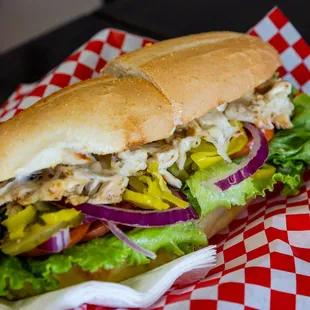 a chicken sandwich with lettuce and onions