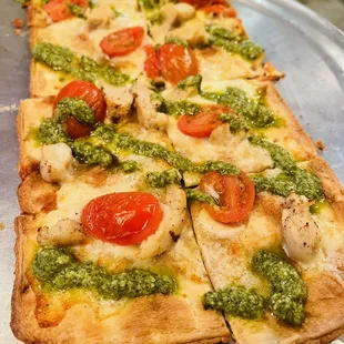 a pizza with pesto sauce