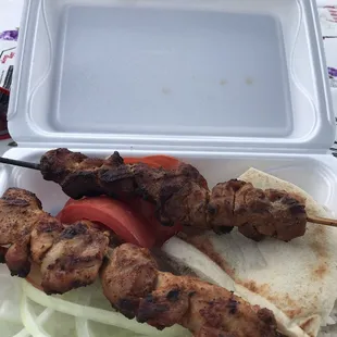 Chicken kebabs come with rice with chickpeas, onions, tomatoes, lettuce and a little piece of pita