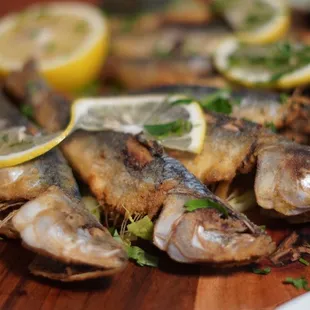 a plate of sardines with lemon slices