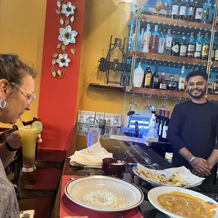 Coconut chicken curry and a Passion Fruit Indian Sunrise with cardamom and cucumber garnish. Love it!