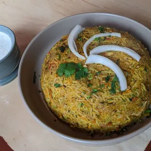 a bowl of rice with onions and cilantro