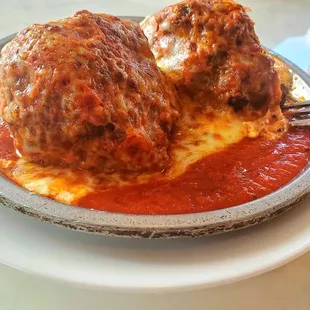 Stuffed meatballs on ricotta cheese covered in sauce and melted mozzarella cheese. Delish!