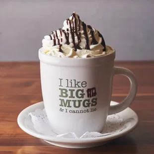 a cup of coffee with whipped cream and chocolate drizzle