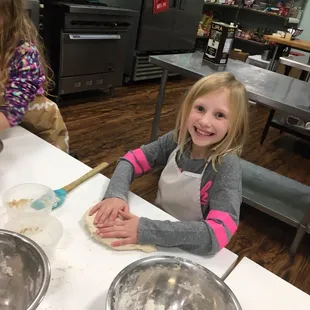 Birthday girl making pizza dough