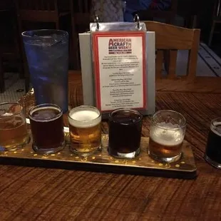 ows a flight of beers on a tray