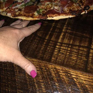 The pizza sitting in the table with my hand underneath it- gross!