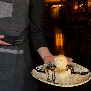 a man holding a plate of dessert