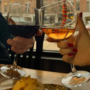 two people toasting with wine glasses