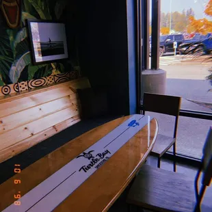 a surfboard on a table in front of a window