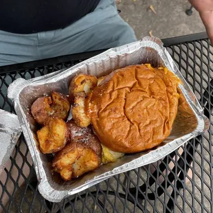 Breakfast sandwich with bacon and side of potatoes