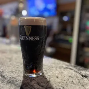 a glass of guinness on a bar