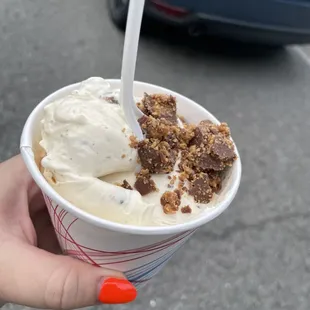 a hand holding a cup of ice cream
