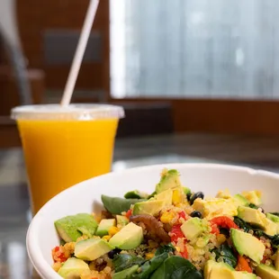 a bowl of food and a glass of orange juice