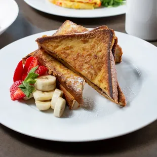 a plate of french toast and fruit