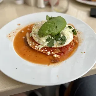 Huevos Rancheros - crisp corn tortillas, refried beans, topped with over-easy eggs, crema, queso fresco, and avocado