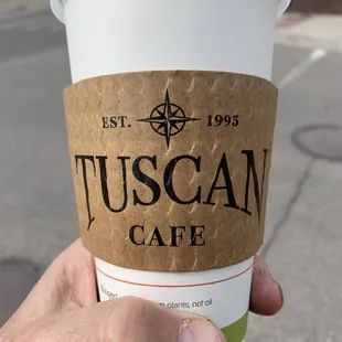 a hand holding a cup of coffee