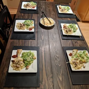 a wooden table with plates of food