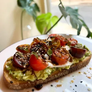 a slice of toast with avocado and tomatoes