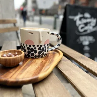 a cup of coffee on a wooden tray