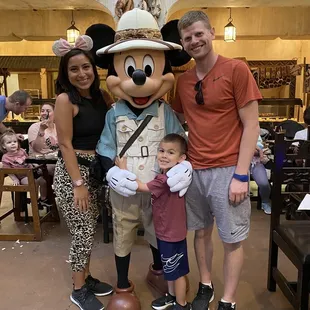 a family posing with mickey mouse