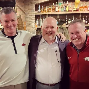 two men and a woman posing for a picture