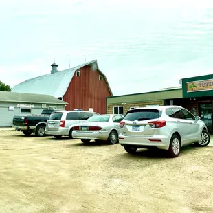 several cars parked in front of a barn
