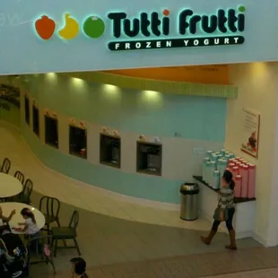 a woman walking through a frozen yogurt store