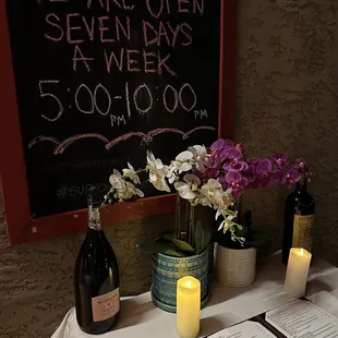 a table with wine bottles and flowers