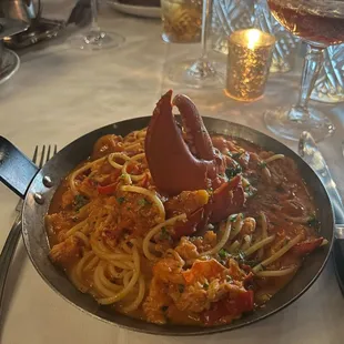 a plate of spaghetti with a lobster
