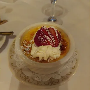 a bowl of dessert with whipped cream and strawberries