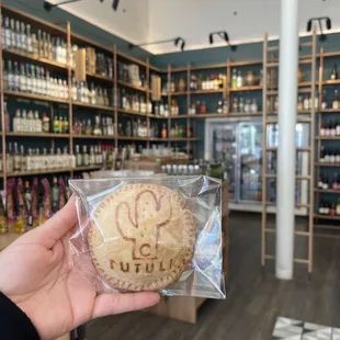 a hand holding a cookie in a store