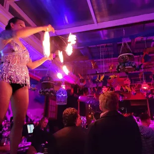 a woman in a sequinned outfit performing a fire show