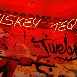 a neon sign on a brick wall